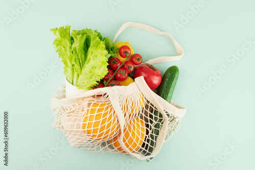 Fototapeta Naklejka Na Ścianę i Meble -  string bag with orange fruits with vegetables and fruits,Responsible consumption with a net bag
