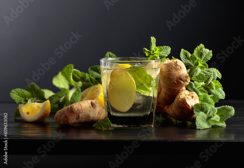Cold refreshing drink with ice, ginger, lemon, and mint.