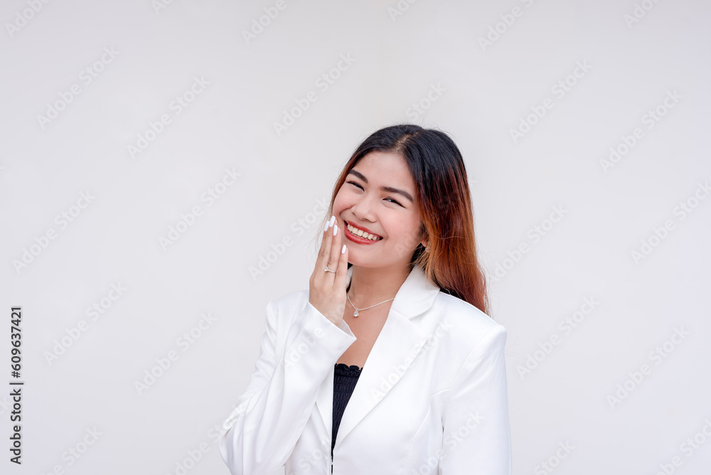 A timid and shy young woman looking at the camera with one hand covering her mouth. Isolated on a white background. A timid and shy young woman looking at the camera with one hand covering her mouth. Isolated on a white background.