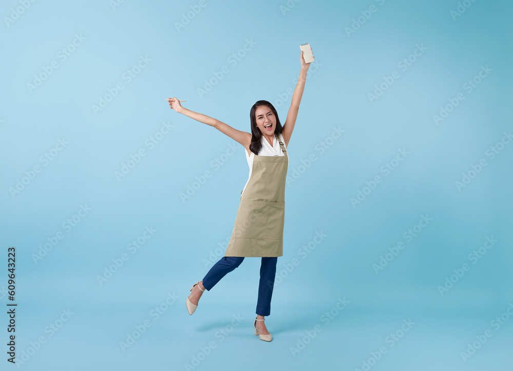 happy celebrating asian woman entrepreneur isolated on blue studio background.