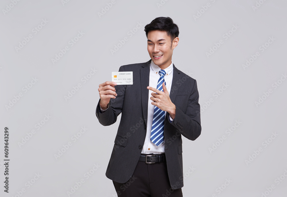 Handsome southeast Asian business man in standing and showing credit card isolated on white studio background. Handsome southeast Asian business man in standing and showing credit card isolated on white studio background.