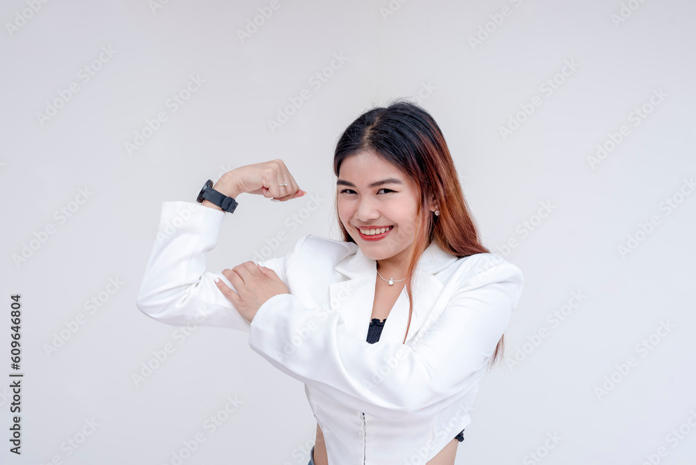 An enthusiastic young woman showing strong gesture and flexing her arms. Isolated on a white background. An enthusiastic young woman showing strong gesture and flexing her arms. Isolated on a white background.