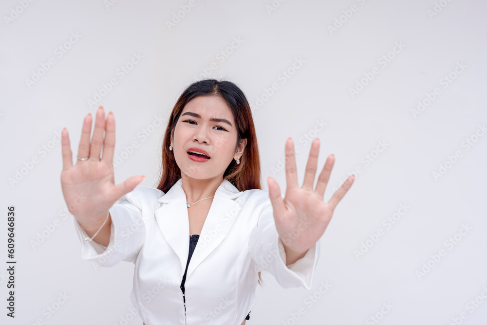 A young asian woman desperately pleads someone to stop and keep distance. Isolated on a white background. A young asian woman desperately pleads someone to stop and keep distance. Isolated on a white background.