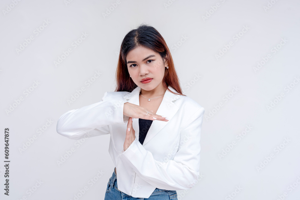 A displeased young woman looking at the camera while gesturing a time-out. Isolated on a white background. A displeased young woman looking at the camera while gesturing a time-out. Isolated on a white background.