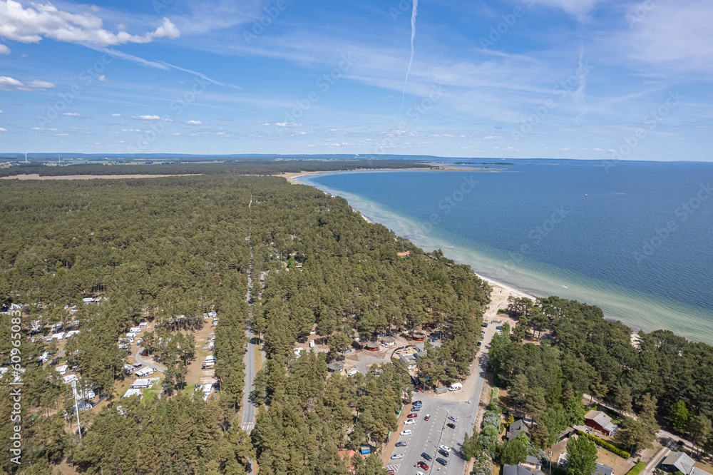 Aerial view of a beach and sea. Beautiful sea, maritime landscape, seascape. Forest near the beach. Sunny summer day. Resort and recreational area. 