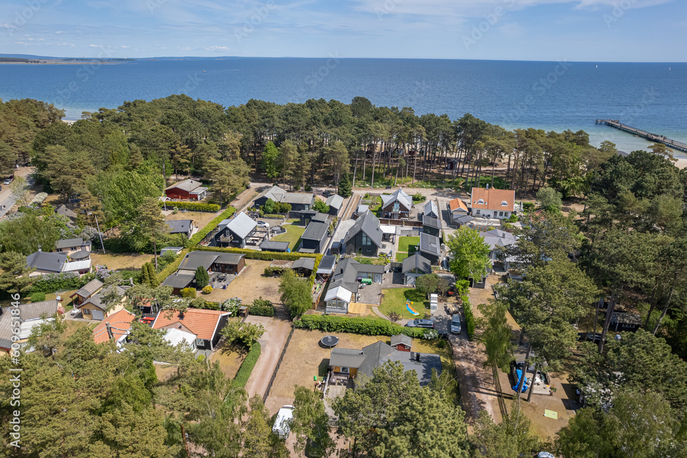 Aerial view private houses close to the beach and sea. Beautiful sea, maritime landscape, seascape. Forest near the beach. Resort and recreational area, luxury real estate.  