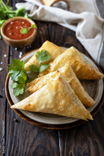 Asian food. Vegetarian samsa (samosas) with tomato sauce on a wooden table. Popular in Indonesia as Risoles Sayur.