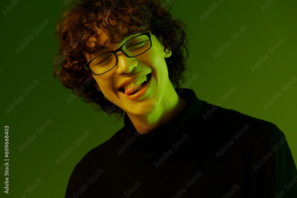 Man young man portrait close-up portrait in glasses fashion smile, hipster lifestyle, portrait green background mixed neon light, copy space Man young man portrait close-up portrait in glasses fashion smile, hipster lifestyle, portrait green background mixed neon light, copy space