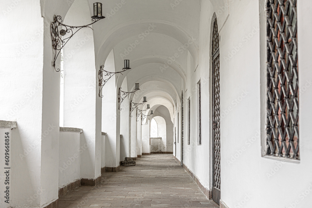 Obraz premium Long corridor of an old building with windows.