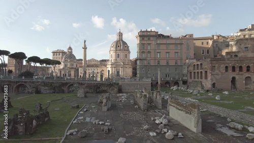 Slowly pan right on Traian Forum Square and view of its colonnade and Trajan's column iwith skyline historical palaces and church n Rome photo