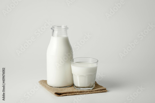 A glass and bottle of milk of milk on a white background