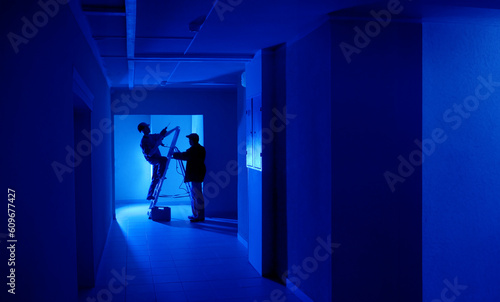 Workers in dark room. Corri...