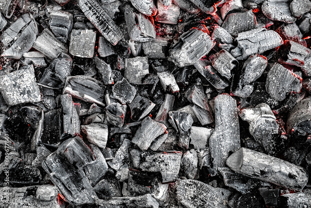 The texture of burning firewood and charcoal with the remnants of the heat. Ash after the fire. Light back. The texture of burning firewood and charcoal with the remnants of the heat. Ash after the fire. Light back.
