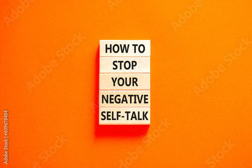Stop negative self-talk symbol. Concept words How to stop your negative self-talk on wooden block. Beautiful orange table orange background. Psychological negative self-talk concept. Copy space