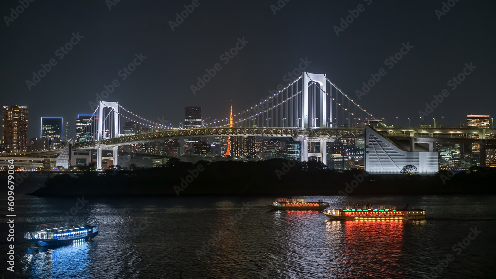 Rainbow bridge and ships with Tokyo tower at night, Japan