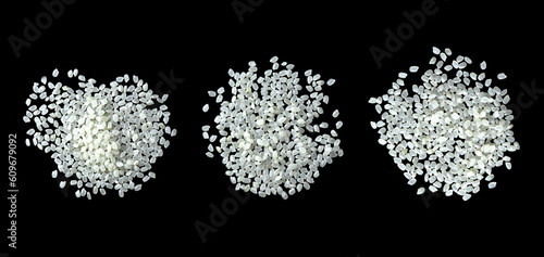 Heaps of uncooked Japanese short grain rice piled together isolated on black background.