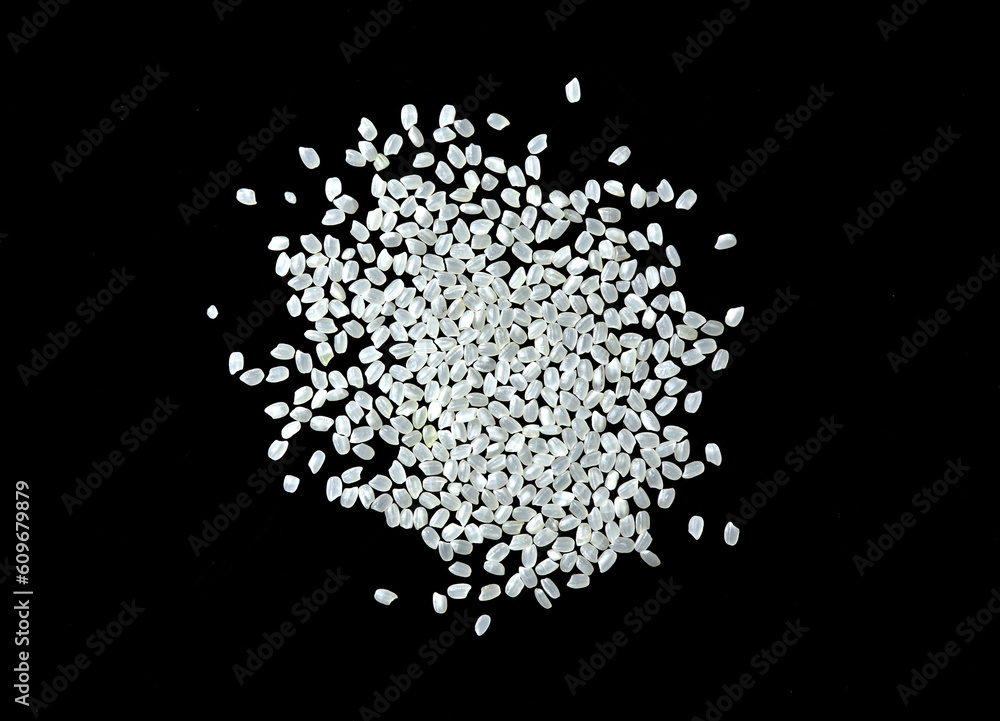 Obraz premium Heaps of uncooked Japanese short grain rice piled together isolated on black background.