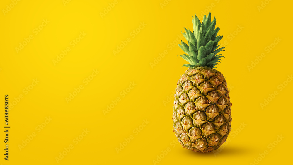 A tropical pineapple isolated on empty yellow background A tropical pineapple isolated on empty yellow background