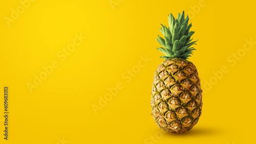 A tropical pineapple isolated on empty yellow background