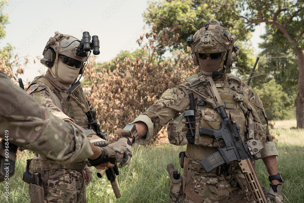 Special forces soldier in camouflage, fist bump and send energy to each other before performing an attack on. Special forces soldier in camouflage, fist bump and send energy to each other before performing an attack on.