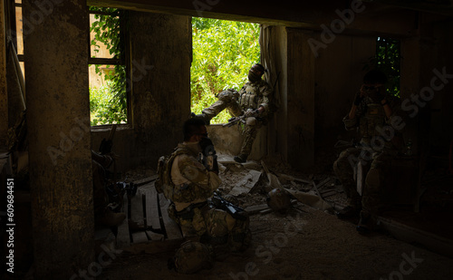 Special forces soldier in camouflage  Take refuge in an abandoned building before starting a new patrol operation.