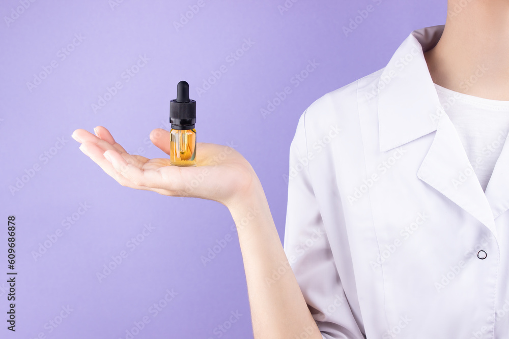 On the palm of a woman doctor is a glass bottle with a pipette with an extract of cbd oil. Alternative treatment with medical cannabis. On the palm of a woman doctor is a glass bottle with a pipette with an extract of cbd oil. Alternative treatment with medical cannabis.