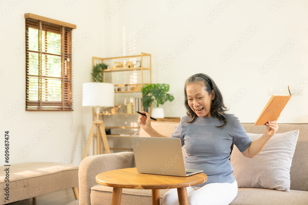 An old businesswoman in her sixties sitting at a table using a laptop. middle aged woman working at home Meet and chat online using the internet on social media. An old businesswoman in her sixties sitting at a table using a laptop. middle aged woman working at home Meet and chat online using the internet on social media.