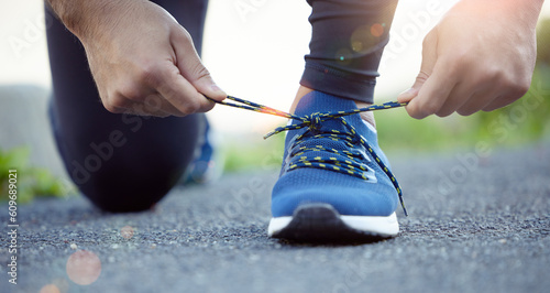 Shoes, hands and man tying shoelace for run, fitness outdoor for exercise, cardio and active with health and closeup. Sports, running sneakers and male person start workout with bokeh and training