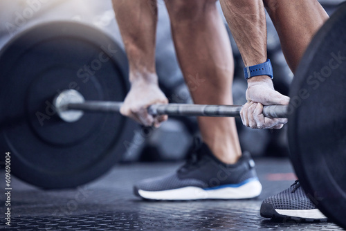Man, training and hands with weight in a closeup at the club for workout with equipment. Male trainer, barbell and lifting with hand on the floor at a gym for strength with muscles for exercise.