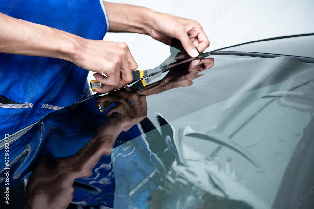 Car side window film removal and tinting installation. Male auto
