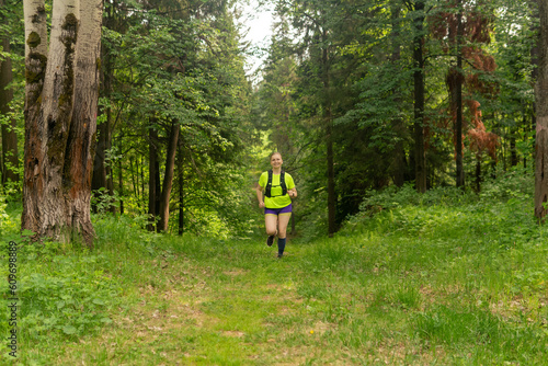 young woman jogging on a trail in a natural forest park