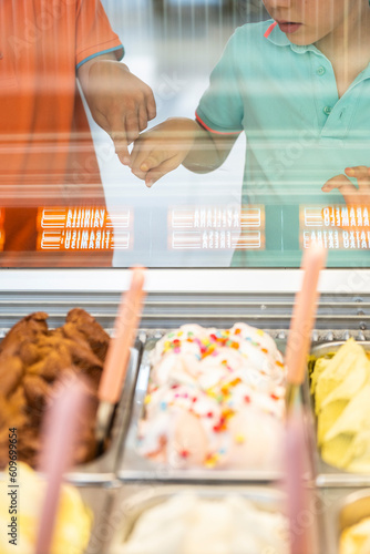 Two children choosing an ice cream flavor in an ice cream shop