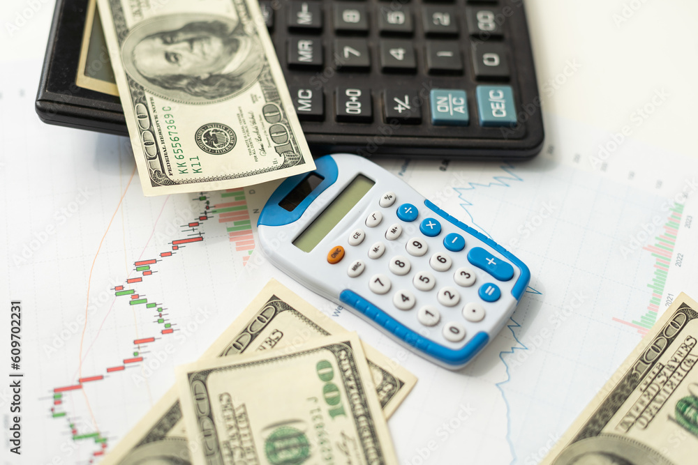 Accounting charts and graphs with us dollar bills pen calculator. Stock market graphs Accounting charts and graphs with us dollar bills pen calculator. Stock market graphs