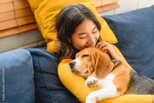 A woman is shown in a friendly interaction with her dog, a playful beagle photo