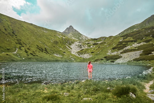 Women tourist on hiking trail in West Tatras mountains in Jamnicka valley near lake under the Ostry Rohac, Liptov, Slovakia.