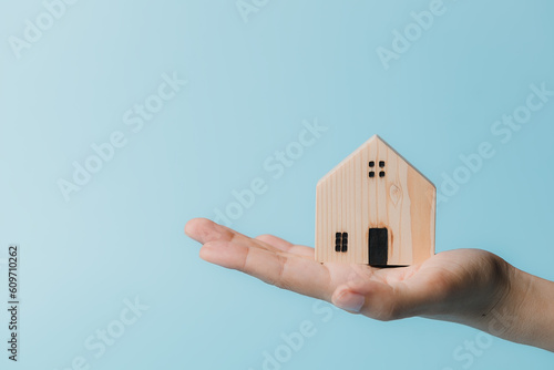 Hand holding a wooden house...