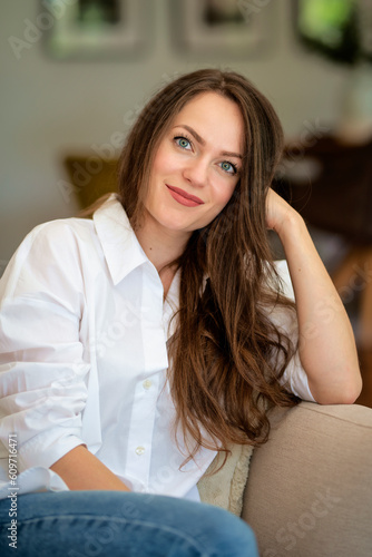 Free Download Portrait of an attractive young woman relaxing in her modern home - GFXLoad