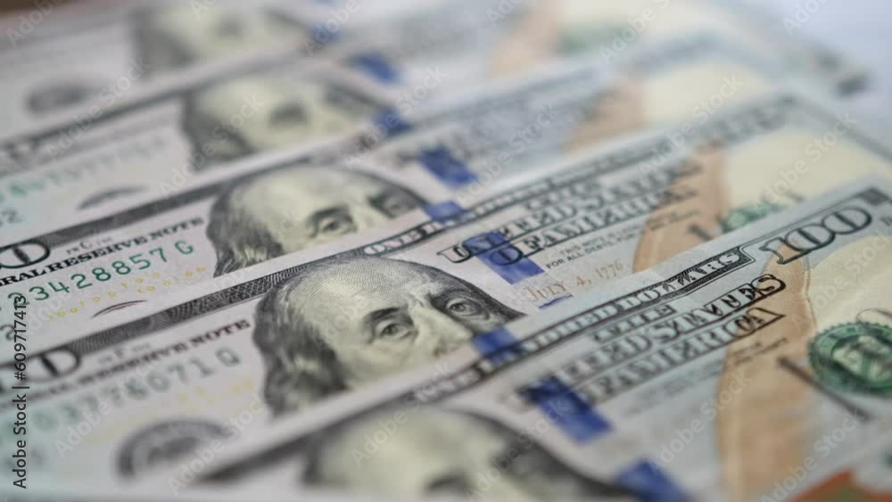 Hundred dollars bills close up in camera motion. Banknotes money laid out in neat rows on the table. Usa President on one hundred dollars bills. Hundred dollars bills close up in camera motion. Banknotes money laid out in neat rows on the table. Usa President on one hundred dollars bills.