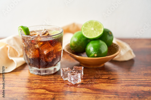 Rum and Cola Cuba Libre with Lime and Ice, cocktail from caribbean, Focus selective.