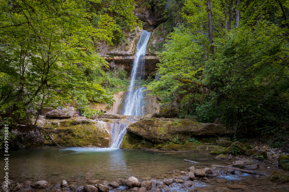 Obraz premium La Cascade du Moulin de Vulvoz se situe dans le Jura au Sud de Saint Claude. Du haut de sa chute de 22 mètres, la Cascade du Moulin de Vulvoz est particulièrement impressionnante