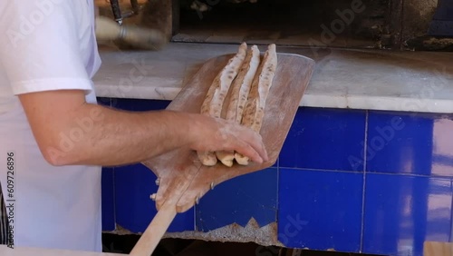Bafra style pide which is a Turkish pizza with meat in a closed bread is placed in a traditional oven heated by wood