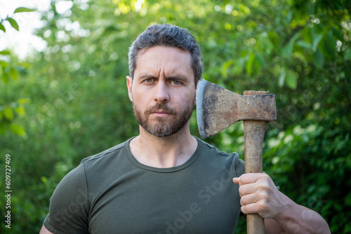 mature bearded masculine guy with axe. masculine guy with axe outdoor.