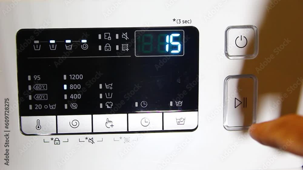 Finger of woman press the switch to make the washing machine work. Home appliances. Finger of woman press the switch to make the washing machine work. Home appliances.