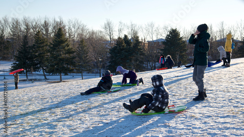 Foto Toronto, Ontario / Canada - Jan 14, 2023:  Winter sport toboggan -  mother and son playing toboggan, winter, outside, healthy lifestyle
