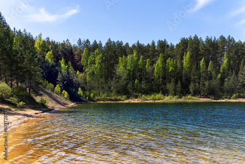 Transparent blue water in a Dubkalnu Reservoir among pine forests at Zilie Kalni (Blue Hills) Nature Park in the Ogre municipality, Latvia, Europe. Clean environment concept. photo