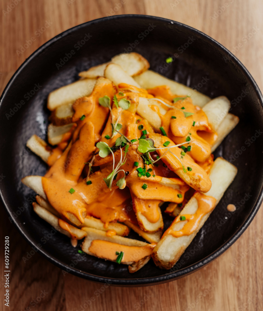 Racion de patatas fritas con queso cheddar estilo americano Racion de patatas fritas con queso cheddar estilo americano
