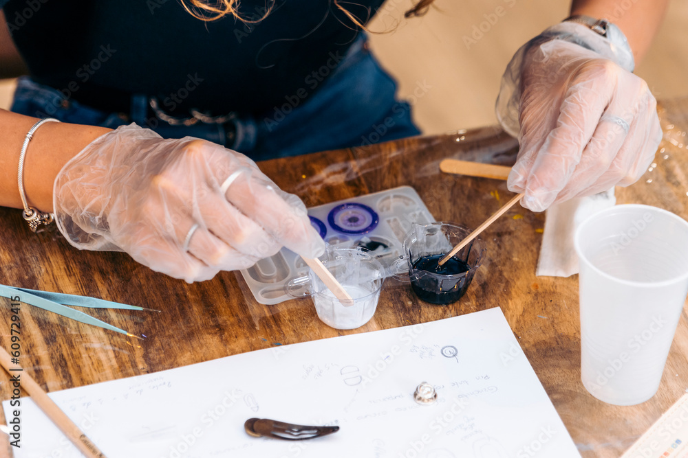 Fototapeta premium Epoxy jewelry workshop. Resin Delights: Women Express Creativity Making Unique Epoxy Earrings