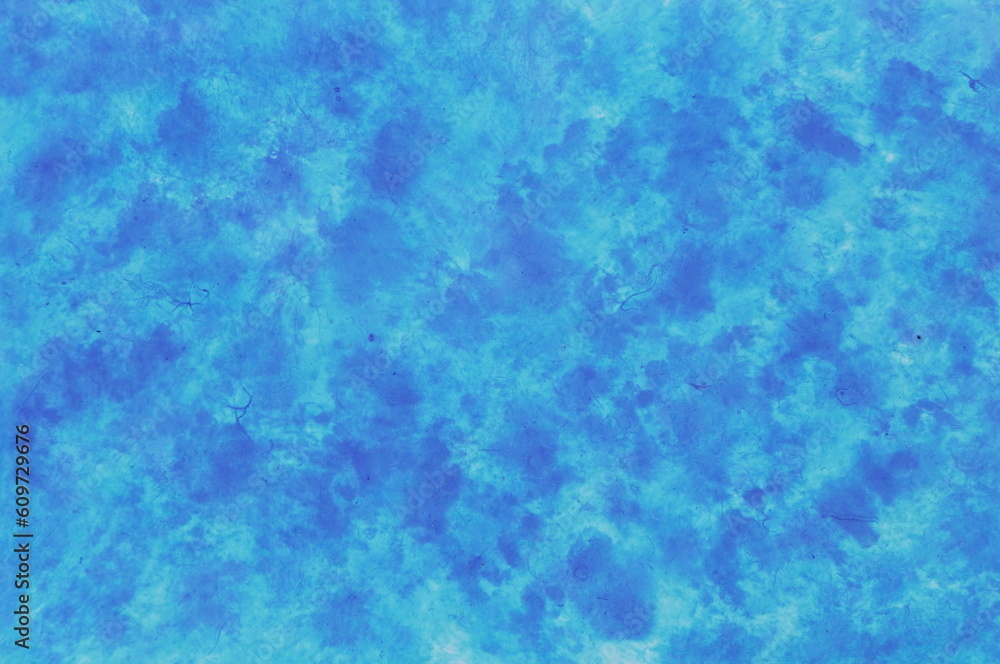 Speckled background of paper colored in shades of blue Speckled background of paper colored in shades of blue