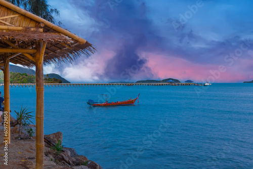 Colourful Skies Sunset over Rawai Beach in Phuket island Thailand. Lovely turquoise blue waters, lush green mountains colourful skies and beautiful views the pier and longtail boats and islands  © Elias Bitar