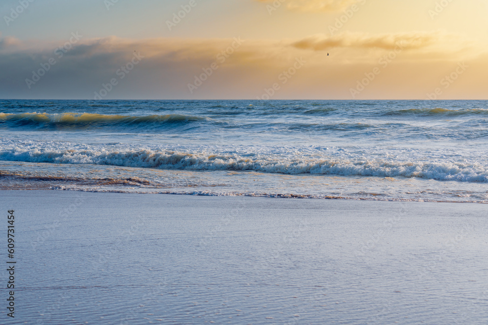 Blue ocean, and beautiful cloudy sky. The tranquil scene, golden sunset on the beach